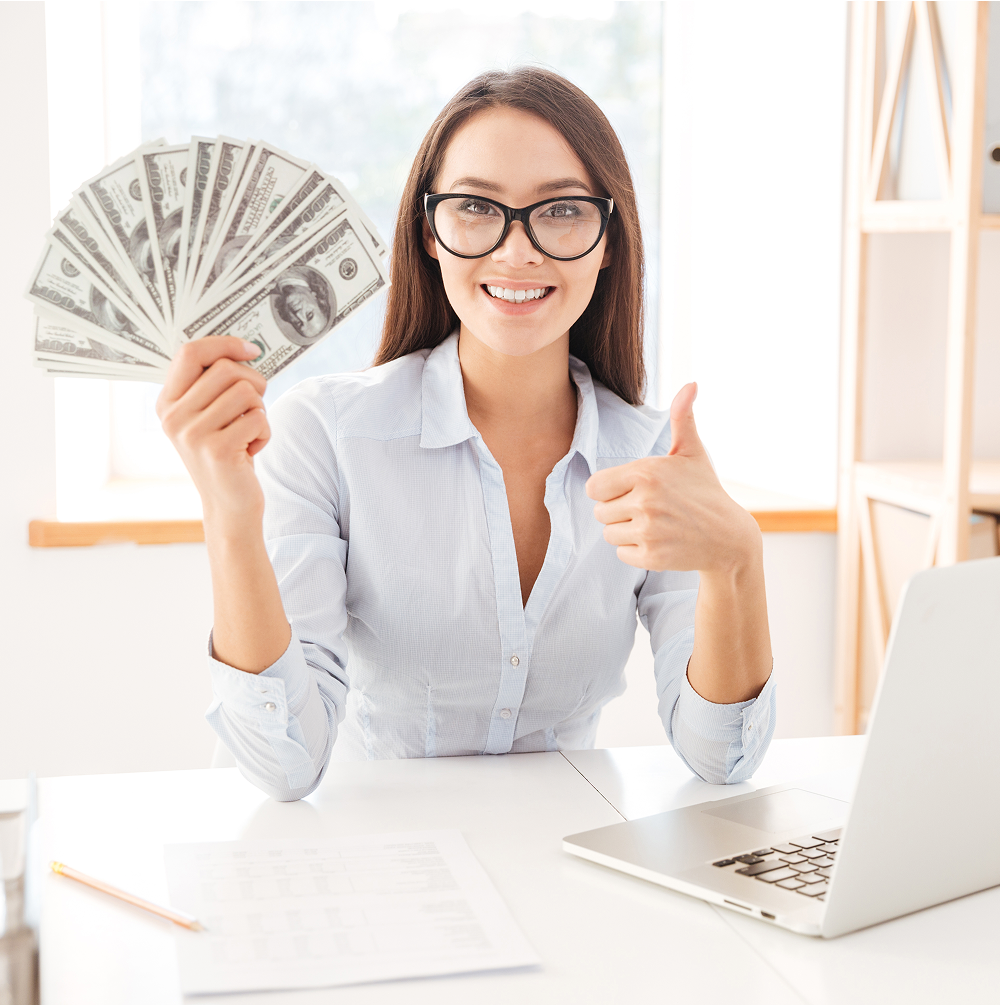 image-of-businesswoman-dressed-in-white-shirt-sitting-in-her-office-and-holding-money--SBI-302898072 1 How Much Money Should I Keep in My Savings Account?